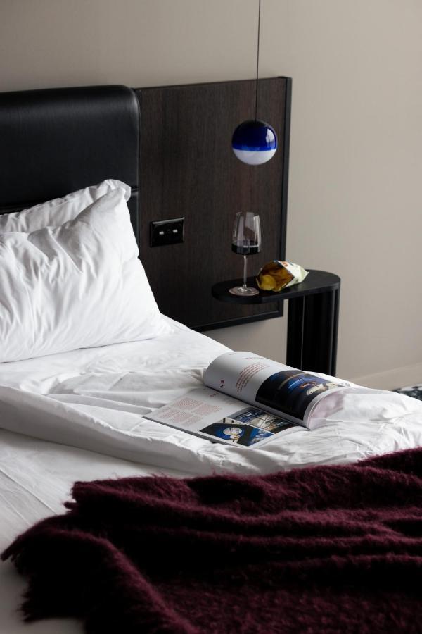 Ebb-Dunedin Extérieur photo A bed with a magazine and a wine bottle